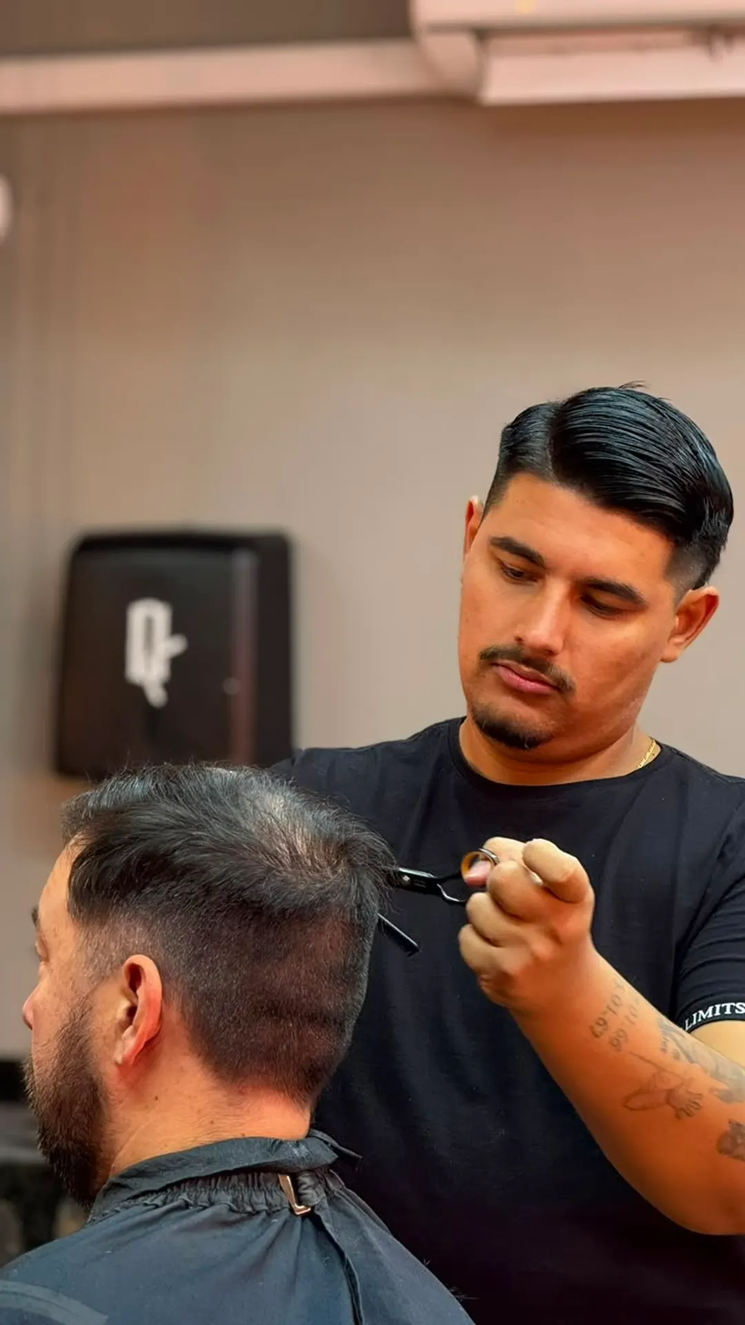 Barbeiro da Queiroz Barber Club em Viamão cortando com tesoura