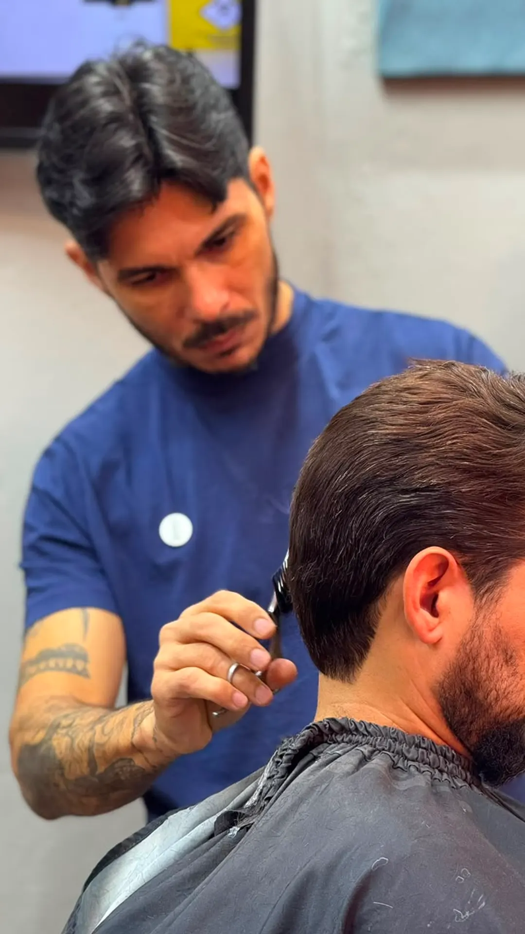 Barbeiro da Queiroz Barber Club em Viamão fazendo o acabamento com máquina